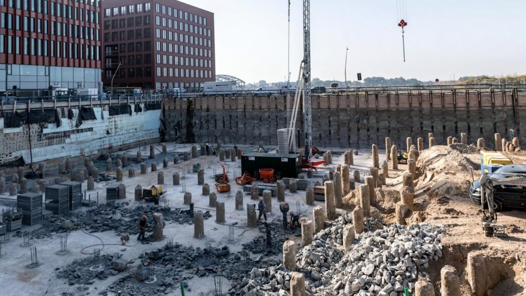The Art of Drawing Readers In: Your attractive post title goes here A bustling urban construction site with workers and heavy machinery near tall buildings.