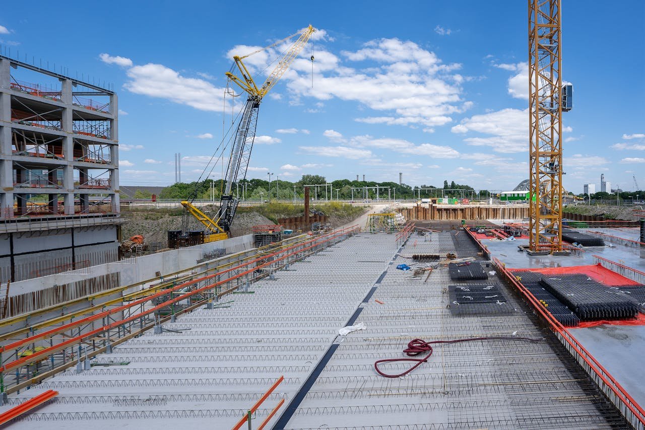 Crafting Captivating Headlines: Your awesome post title goes here View of a busy construction site with cranes and building structure under clear sky.